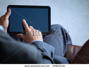 stock-photo-businessman-with-finger-touching-screen-of-a-digital-tablet-whilst-sitting-on-a-sofa-93892240